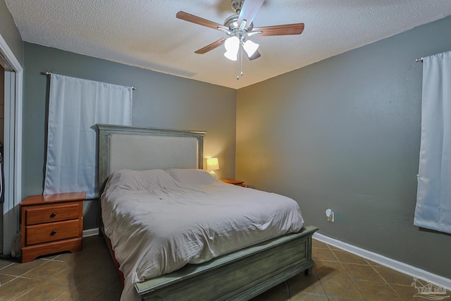 tiled bedroom featuring ceiling fan and a textured ceiling