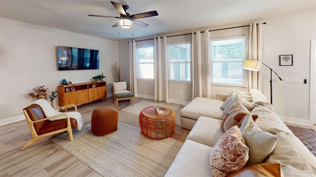 living room featuring ceiling fan, a healthy amount of sunlight, and hardwood / wood-style flooring