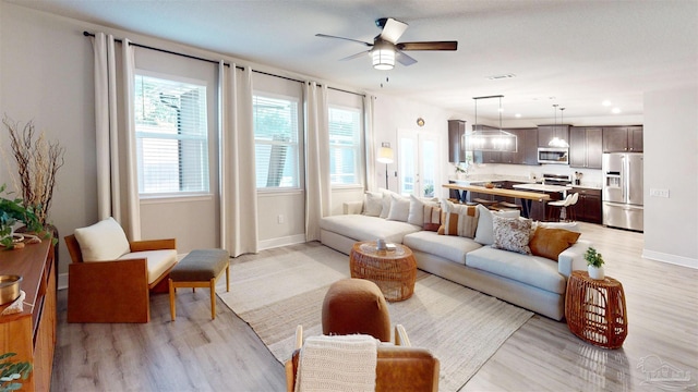 living room featuring light hardwood / wood-style floors, plenty of natural light, and ceiling fan