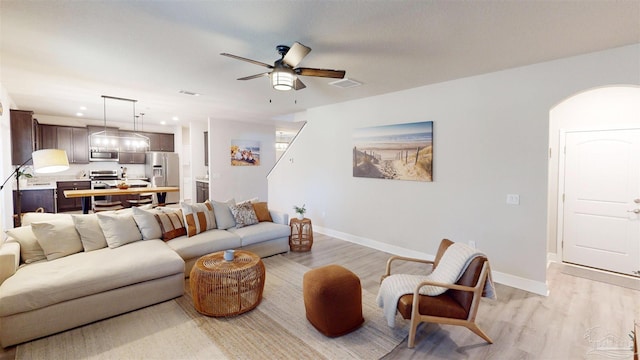 living room featuring ceiling fan and light hardwood / wood-style floors