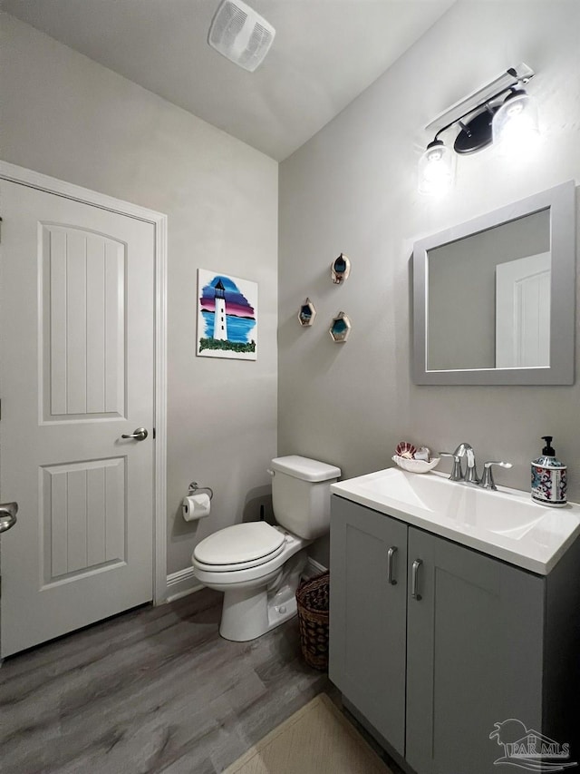 bathroom featuring toilet, wood-type flooring, and vanity