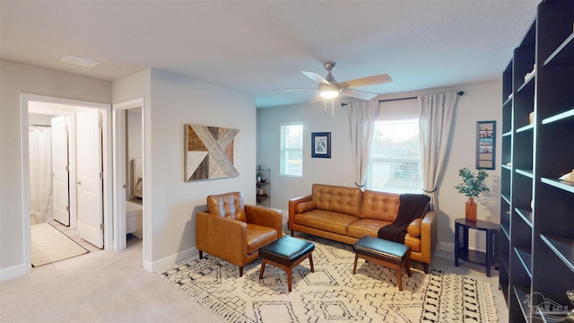 living area featuring ceiling fan and light colored carpet