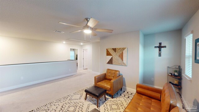 sitting room with ceiling fan, light colored carpet, and a wealth of natural light