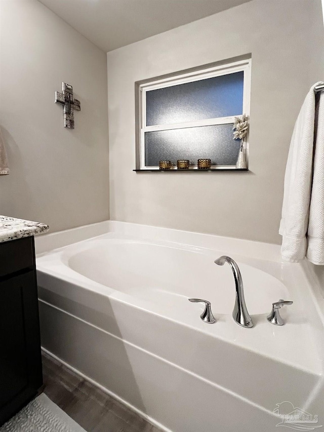 bathroom featuring a tub, hardwood / wood-style flooring, and vanity