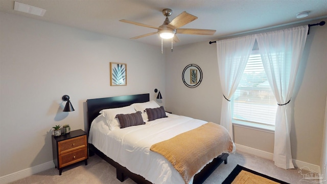 bedroom with light carpet, ceiling fan, and multiple windows