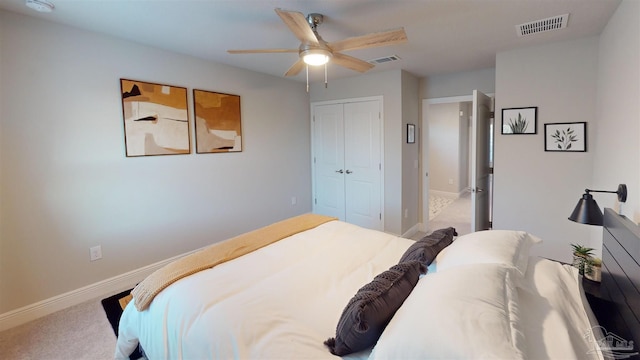 bedroom with ceiling fan, a closet, and light carpet