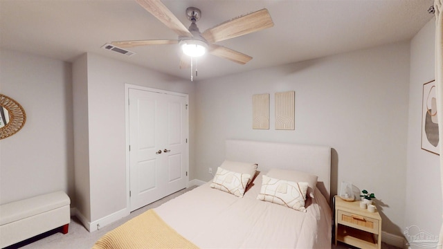 carpeted bedroom featuring ceiling fan and a closet