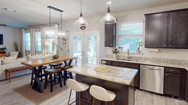 kitchen featuring decorative light fixtures, sink, dark brown cabinetry, and dishwasher