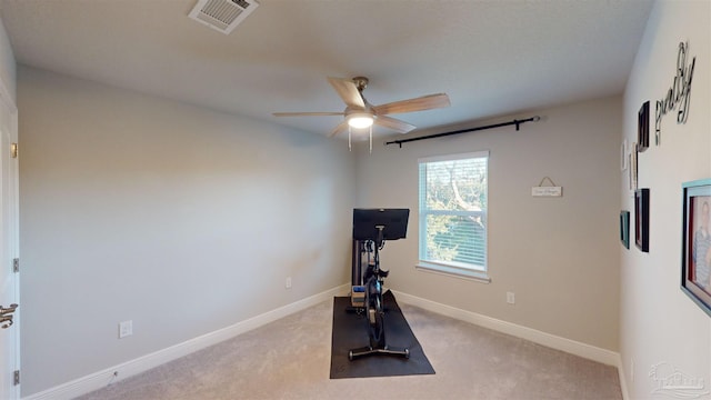 exercise room featuring ceiling fan and light carpet