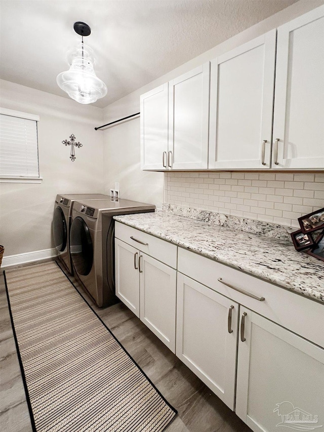 laundry room featuring cabinets, dark hardwood / wood-style floors, and washing machine and clothes dryer