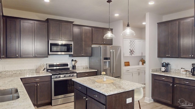 kitchen featuring dark brown cabinets, stainless steel appliances, and light hardwood / wood-style flooring