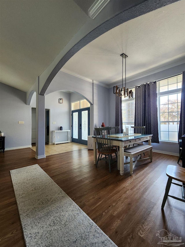 dining room with french doors, ornamental molding, dark hardwood / wood-style flooring, and a notable chandelier