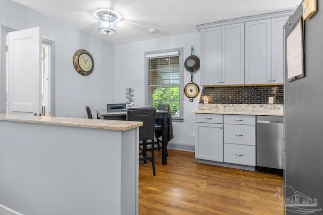 kitchen with gray cabinets, dishwasher, backsplash, and light hardwood / wood-style floors