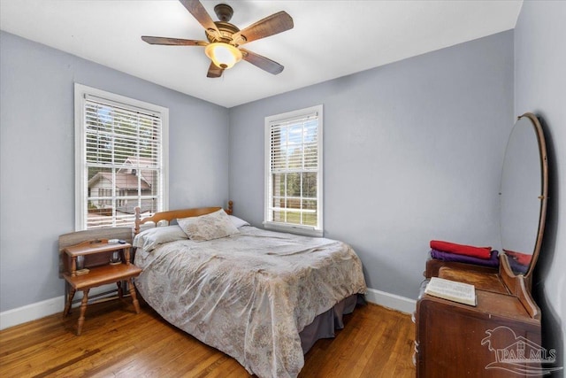 bedroom with light hardwood / wood-style flooring, ceiling fan, and multiple windows