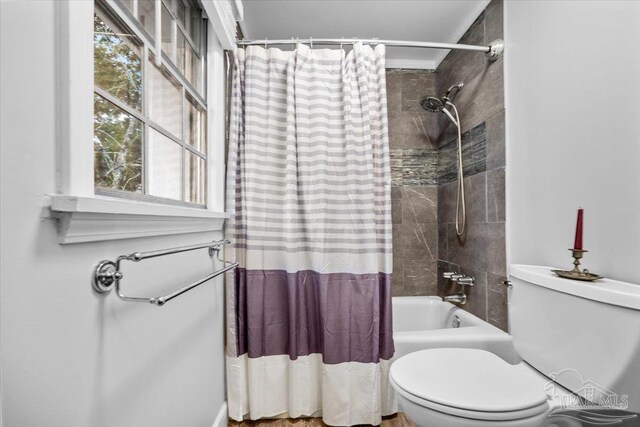 bathroom with shower / bath combo with shower curtain and toilet