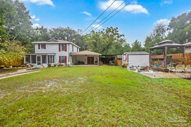 view of yard with a gazebo, a storage shed, and a sunroom