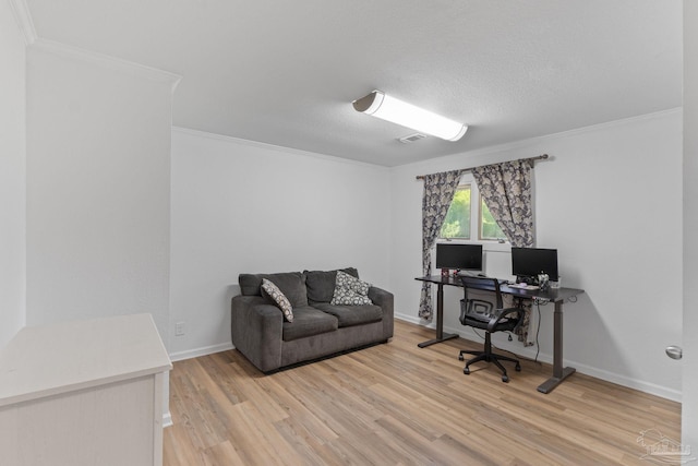 office with crown molding, visible vents, baseboards, and light wood-type flooring