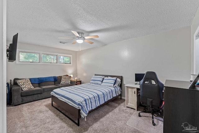 bedroom featuring a textured ceiling, light colored carpet, a ceiling fan, and visible vents