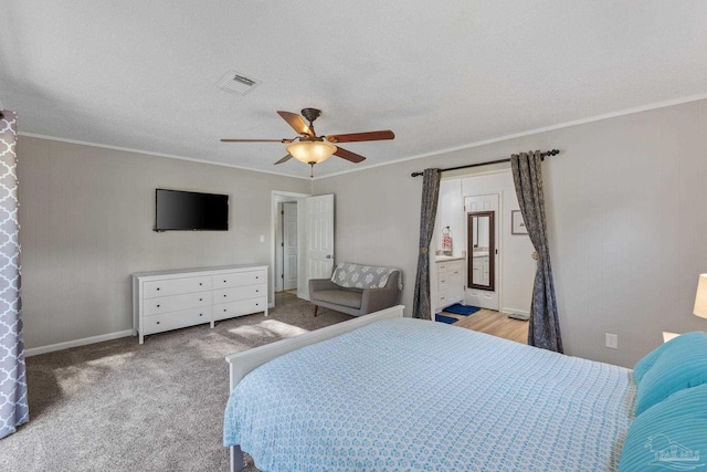 bedroom featuring baseboards, crown molding, carpet floors, visible vents, and ceiling fan