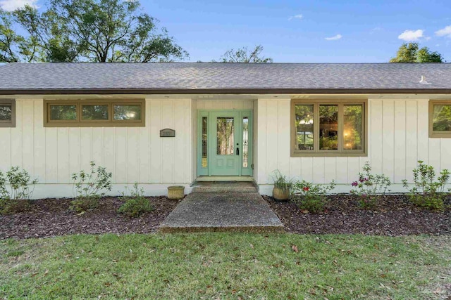 entrance to property with board and batten siding and roof with shingles