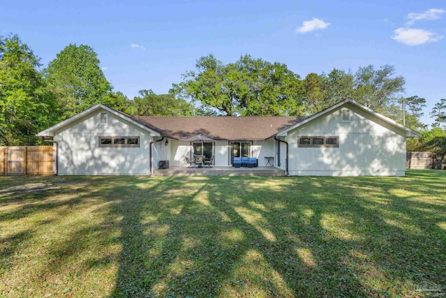 view of front of property with an attached garage, a patio, fence, and a front lawn
