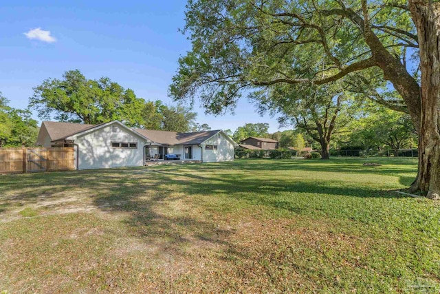 view of yard with an attached garage and fence