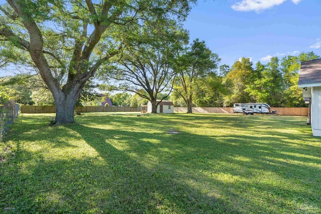 view of yard with an outbuilding, a shed, and a fenced backyard
