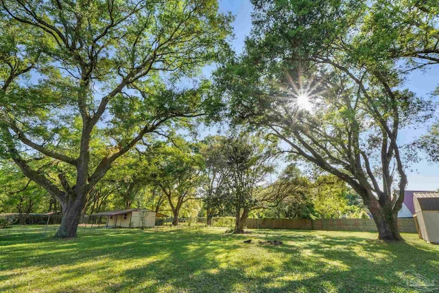 view of yard featuring a shed, a fenced backyard, and an outdoor structure