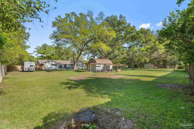 view of yard featuring a shed, a fenced backyard, and an outdoor structure