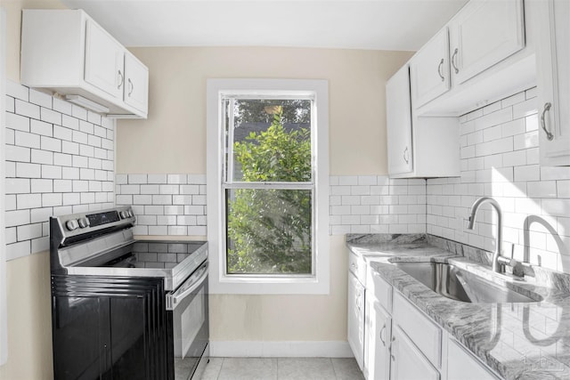 kitchen with light stone countertops, a sink, stainless steel range with electric stovetop, and white cabinetry