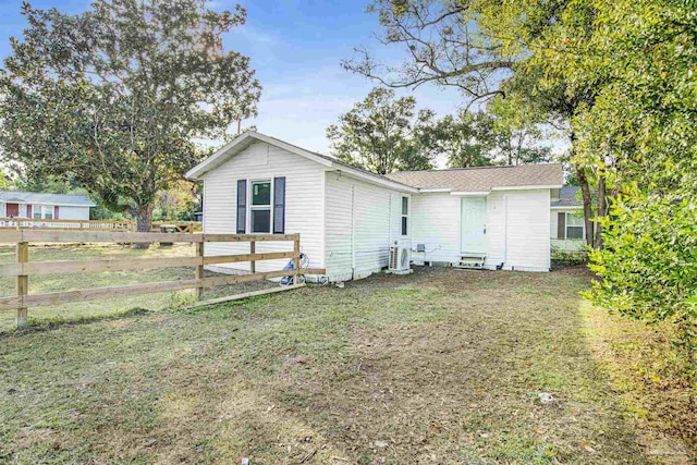 back of house featuring a yard and fence