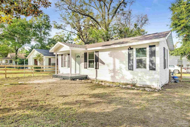 ranch-style home with a front yard and fence