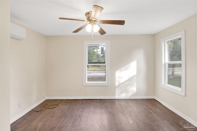 empty room with dark wood-style floors, ceiling fan, baseboards, and a wall mounted AC