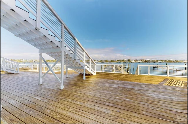 wooden terrace with a water view and stairway