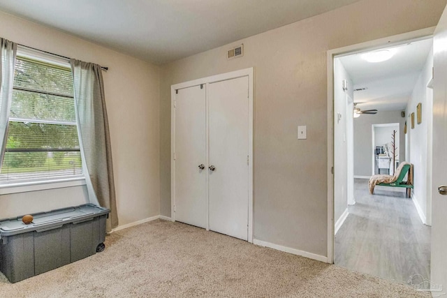 unfurnished bedroom featuring a closet and light colored carpet