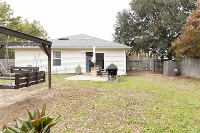 back of property with a yard and a patio