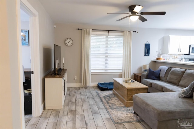 living room featuring ceiling fan and light hardwood / wood-style floors