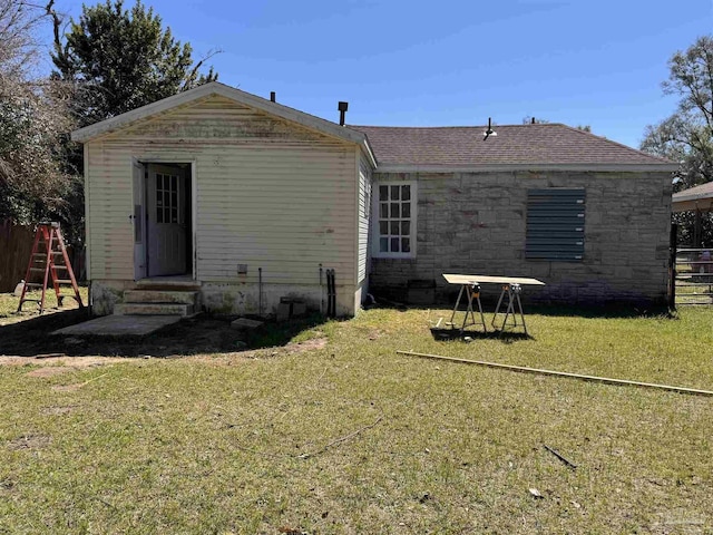 back of house with a playground, a shingled roof, a lawn, entry steps, and fence