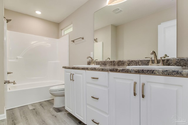 full bathroom with shower / bathing tub combination, wood-type flooring, vanity, and toilet