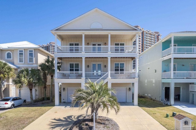 beach home with concrete driveway, a porch, board and batten siding, and an attached garage