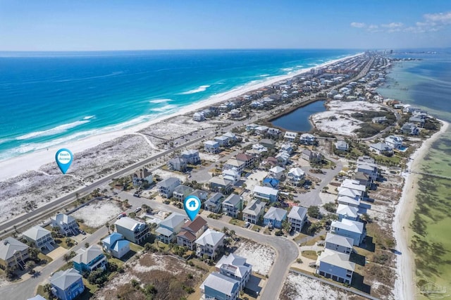 drone / aerial view with a beach view, a residential view, and a water view