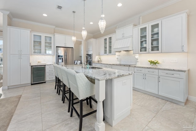 kitchen featuring beverage cooler, visible vents, custom exhaust hood, stainless steel appliances, and crown molding