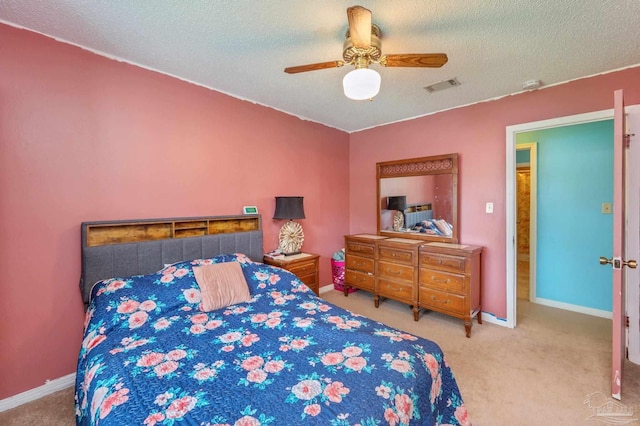 carpeted bedroom featuring a textured ceiling, visible vents, a ceiling fan, and baseboards