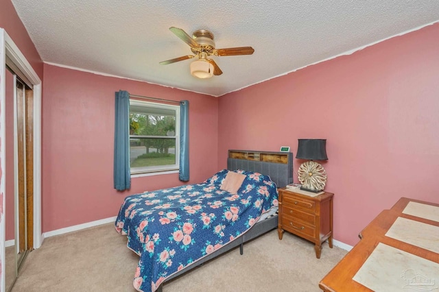 carpeted bedroom featuring a ceiling fan, baseboards, and a textured ceiling