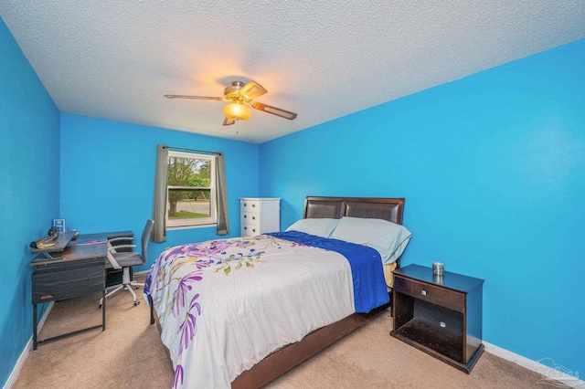 carpeted bedroom with ceiling fan, baseboards, and a textured ceiling