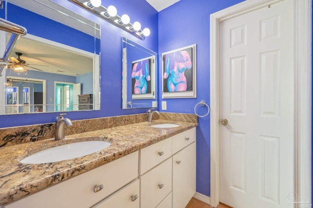 full bathroom with double vanity, ceiling fan, and a sink