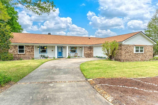 ranch-style house featuring a front lawn, an attached garage, driveway, a porch, and brick siding