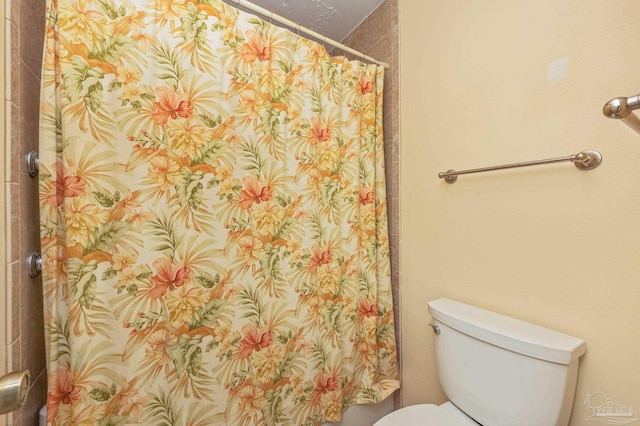 bathroom with toilet and curtained shower