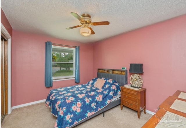 carpeted bedroom featuring baseboards, a ceiling fan, and a textured ceiling