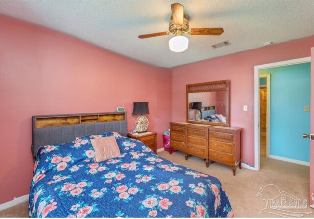 carpeted bedroom featuring baseboards, visible vents, and a textured ceiling